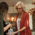 Family Reunion - Woman in Red Shirt Standing Beside Woman in Black Jacket