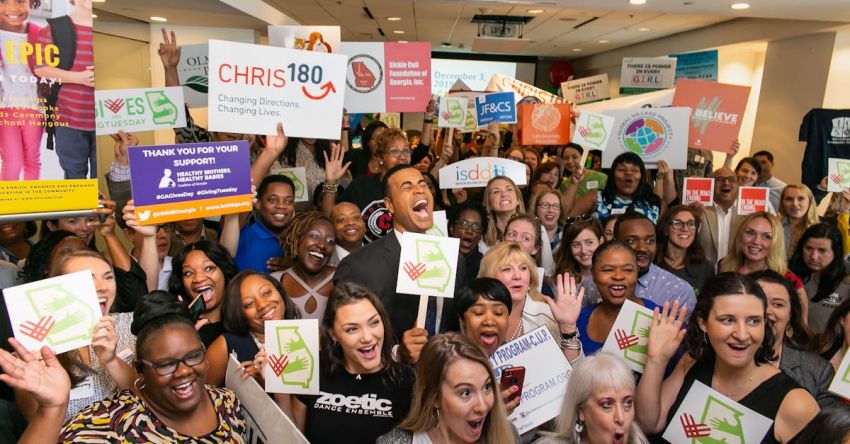 Charity Events - A large group of people cheering at charity event