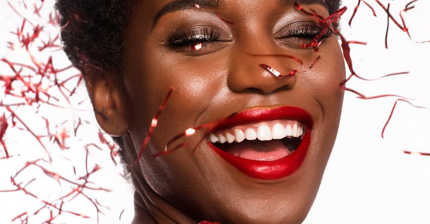 New Year - Close-up Photo of Smiling Woman with Her Eyes Closed Posing As Confetti Drops Down Her Face